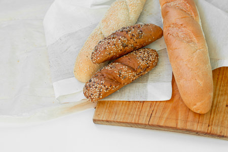 Top view of freshly baked bread, baguette with various seeds (sesame, flax, sunflower) isolated on white background.の写真素材