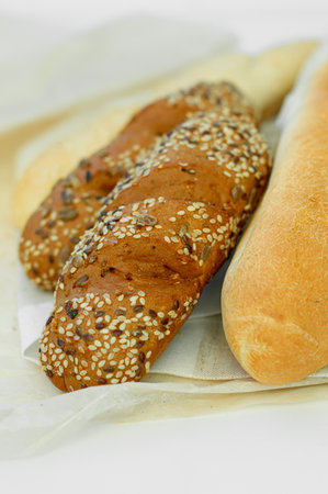 Top view of freshly baked bread, baguette with various seeds (sesame, flax, sunflower) isolated on white background.の写真素材
