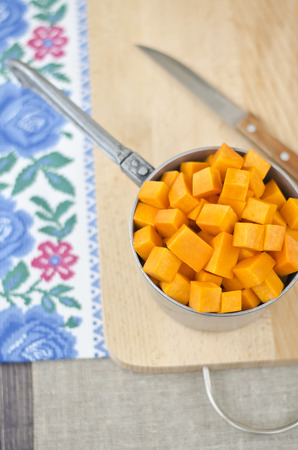 Sliced raw orange pumpkin on the board for cooking.の写真素材