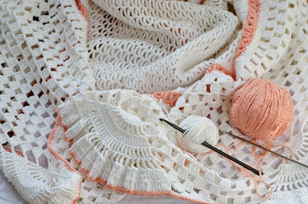 Crochet skirt of white yarn. Skein of yarn and crochet hooks.