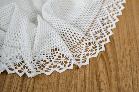 Crochet of white yarn. Skein of yarn and hooks on a wooden table.の写真素材