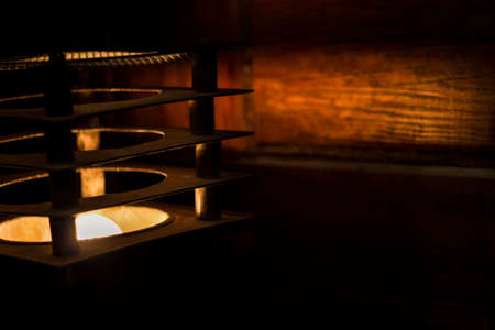 lamp and light in the darkness casts a yellow beam of light on the wooden wallの写真素材