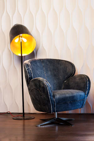 there are chair and glowing shade against the white patterned wall of plasterの写真素材