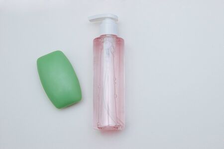 a piece of green soap and antibacterial liquid, sanitizer and gel on a white background top view with free space for textの写真素材