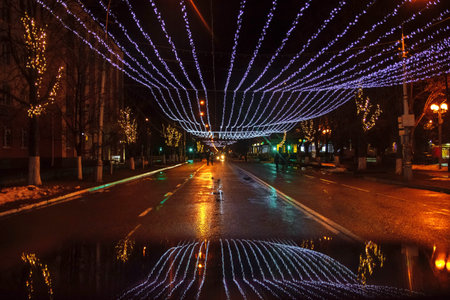Night city landscape on Christmas and new year with lights and garlands on almost empty Avenue after...