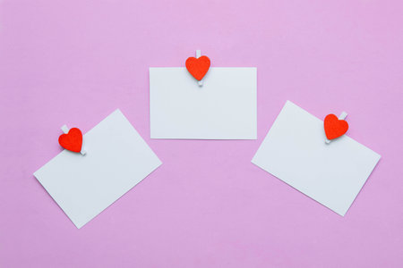 Three white paper cards and notes on pinkの写真素材