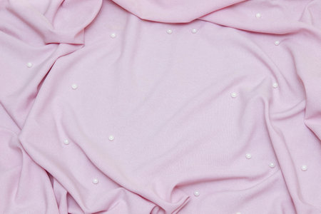 Pink linen fabric background out of focus, with pleats and white pearls with empty space for text, advertising template concept, natural and synthetic fabrics, clothing and accessories, bed linenの写真素材