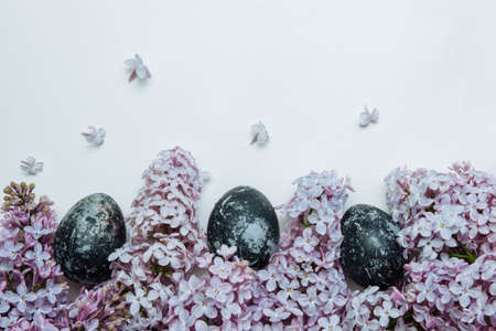 Pink and purple lilac flowers with blue Easter painted Easter eggs on white background with empty space for text, copy space, flat lay, concept of Christian and Catholic Easter, tardis, greeting cardの写真素材