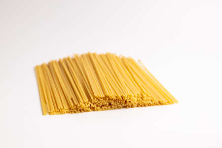 Italian raw spaghetti on craft paper. Close-up. on a white background. Italian cuisine or culinary concept.の写真素材