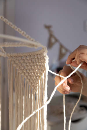 closeup weaving of macrame threads, women's handsの写真素材