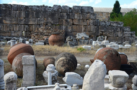 Huge antique clay amphoras against the backdrop of the ruins of the ancient city of Hierapolis near...
