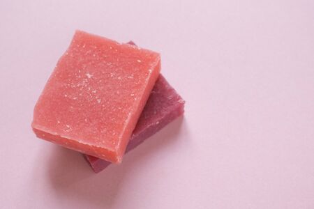 Multi-colored pieces of natural handmade organic soap on pink background with copy space. Concept of hygiene, medicine, health careの写真素材