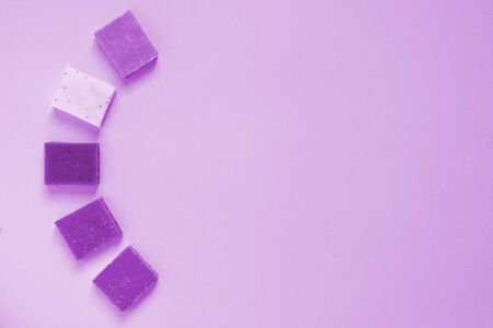 Toned multi-colored pieces of natural handmade organic soap in the form of the letter C on pink background with copy space. Concept of hygiene, medicine, health careの写真素材