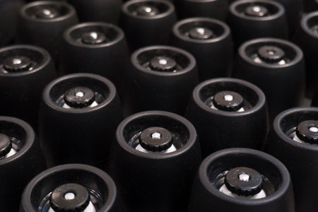 Several rows of containers with black lids at a factory on a conveyor belt, on a production line at...