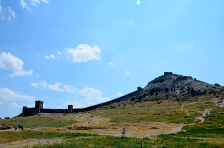 Ruins of the Genoese fortress in Sudak, Crimea, Russia. Tourists walk around the old town on a sunny summer dayのeditorial素材