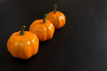 Autumn background of fruits and vegetables: pumpkins on a black background with copy space....