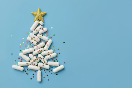 Christmas tree made of white capsules on a blue background with copy space, New Years flat lay, medical concept.の素材