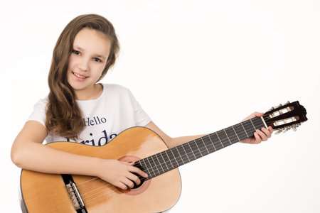 beautiful teenage girl playing on guitar. cute teenager smiling and looking into a camera