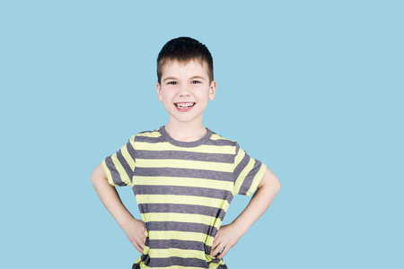 teenager boy smiling and looking into camera on blue background, isolatedの写真素材