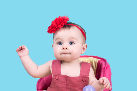 portrait of cute baby with bow flower on her head. baby child looking into the camera. lovely kid...