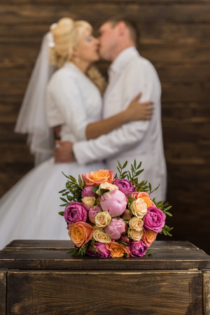 photo wedding bouquet in the foreground, the couple in the blured backgroundの写真素材