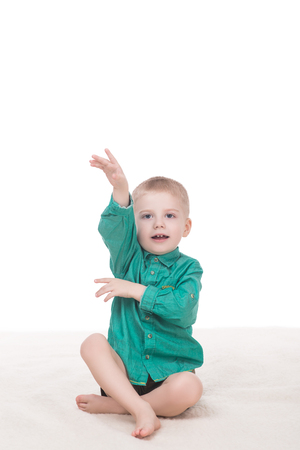 cute little boy raised his hand up, isolated on white backgroundの写真素材