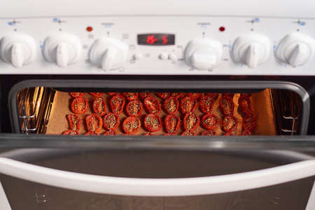 Cooking sun-dried tomatoes in the oven in the kitchen. home cuisineの写真素材
