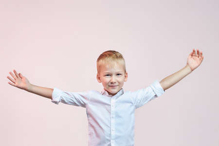 Cute little boy throws up his hands to the sides.の写真素材