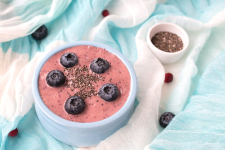 Blueberry smoothie with chia on a blue and white tablecloth, healthy breakfast, top view.