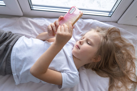 happy little girl is lying at home and smilingの写真素材