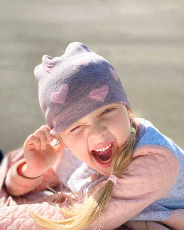 little girl squinted one eye and smilesの写真素材