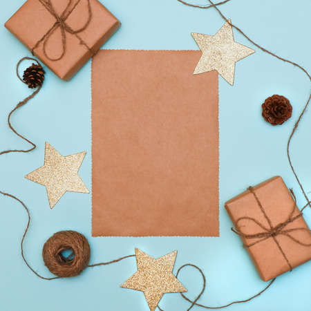 a sheet of craft paper with Christmas decorations and gift boxes. Text space, top view flat layの写真素材