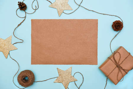 a sheet of craft paper with Christmas decorations and gift boxes. Text space, top view flat layの写真素材