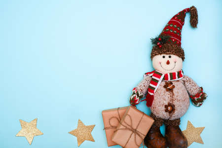 snowman with gifts on a blue background place for text, flat layの写真素材