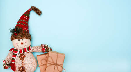 snowman with gifts on a blue background place for text, flat layの写真素材