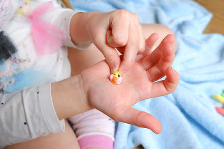 colored plasticine figurine on a child's handの写真素材