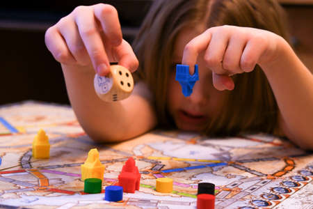 the child's hands hold colored chips on the playing field, board games, a game cubeの写真素材