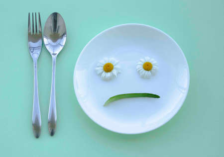 Facial expression on a plate concept. Spoon and forkの写真素材