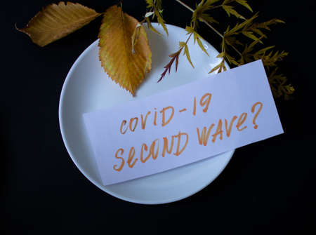 Concept on a black background of a faded autumn bouquet with the inscription covid -19 of the second wave.の写真素材