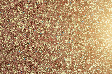 Background of granular stone texture in brown and yellow colors with lens flare. Grain material of...