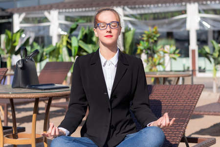 woman office worker sitting in yoga lotus pose at lunchの写真素材