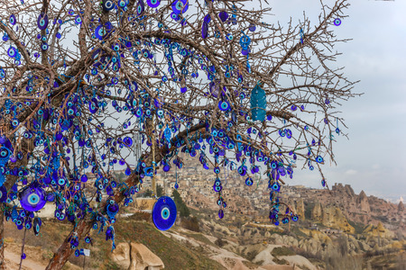 Evil eye in tree behind Uchisar Castle in Cappadocia, Nevsehir , Turkeyの写真素材