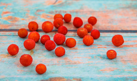 Fresh arbutus fruits on  background imitating an old treeの写真素材