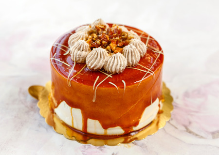 cake with roasted nuts and caramel, decorated with creamの写真素材