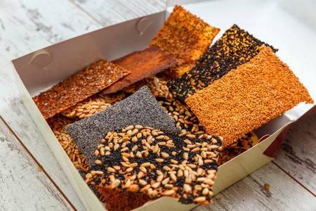 Various kinds of baked thin healthy seed crackers in box (sunflower, sesame, poppy, aniseed,...