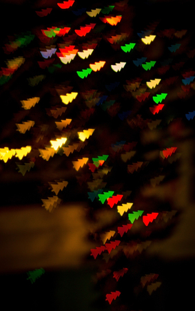 figured bokeh in form of Christmas tree with blur on dark background の写真素材