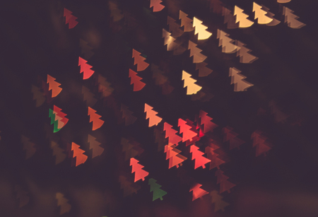 figured bokeh in form of Christmas tree with blur on dark background の写真素材