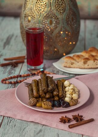 Turkish sarma on a plate with cheese, olives, pide, sorbet drink, rosary and seasonings on the table.  Photo with shallow depth of fieldの写真素材