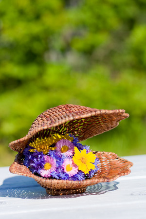 Bouquet Of Bright Wildflowers In Wicker Shellの写真素材