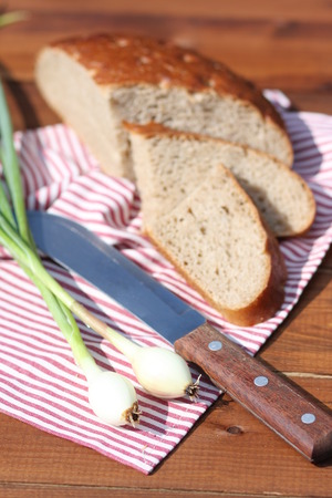 Rye bread, onion and knife on wood, outdoorの写真素材
